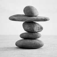 Stack of smooth stones carefully balanced against a clean white background