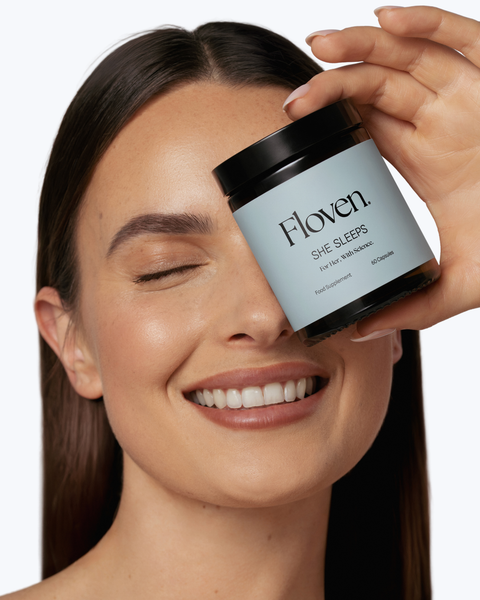 Woman holding a Floven supplement jar close to her face against a clean white background